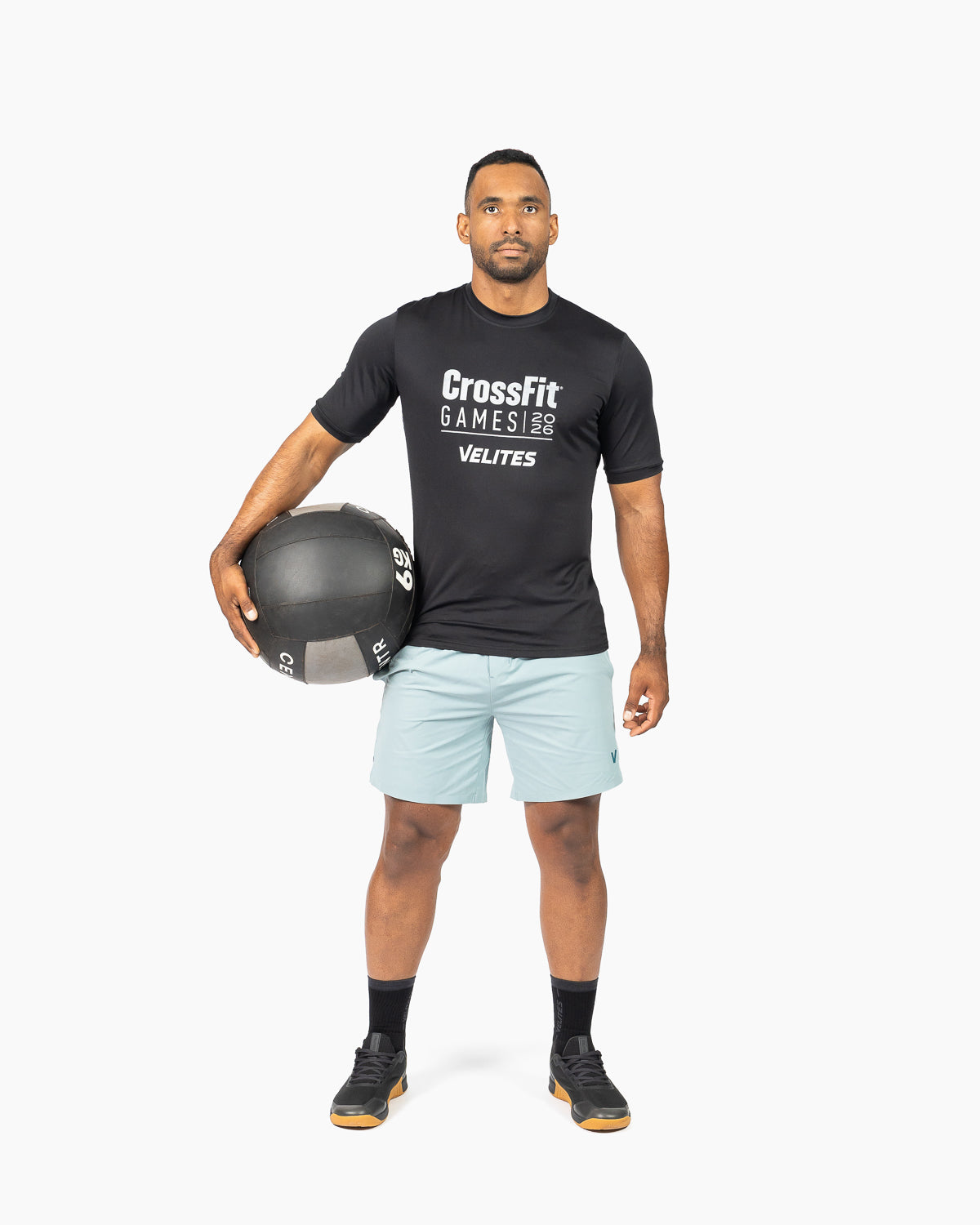 Full body shot of an athlete holding a medicine ball wearing the official CrossFit Games t shirt